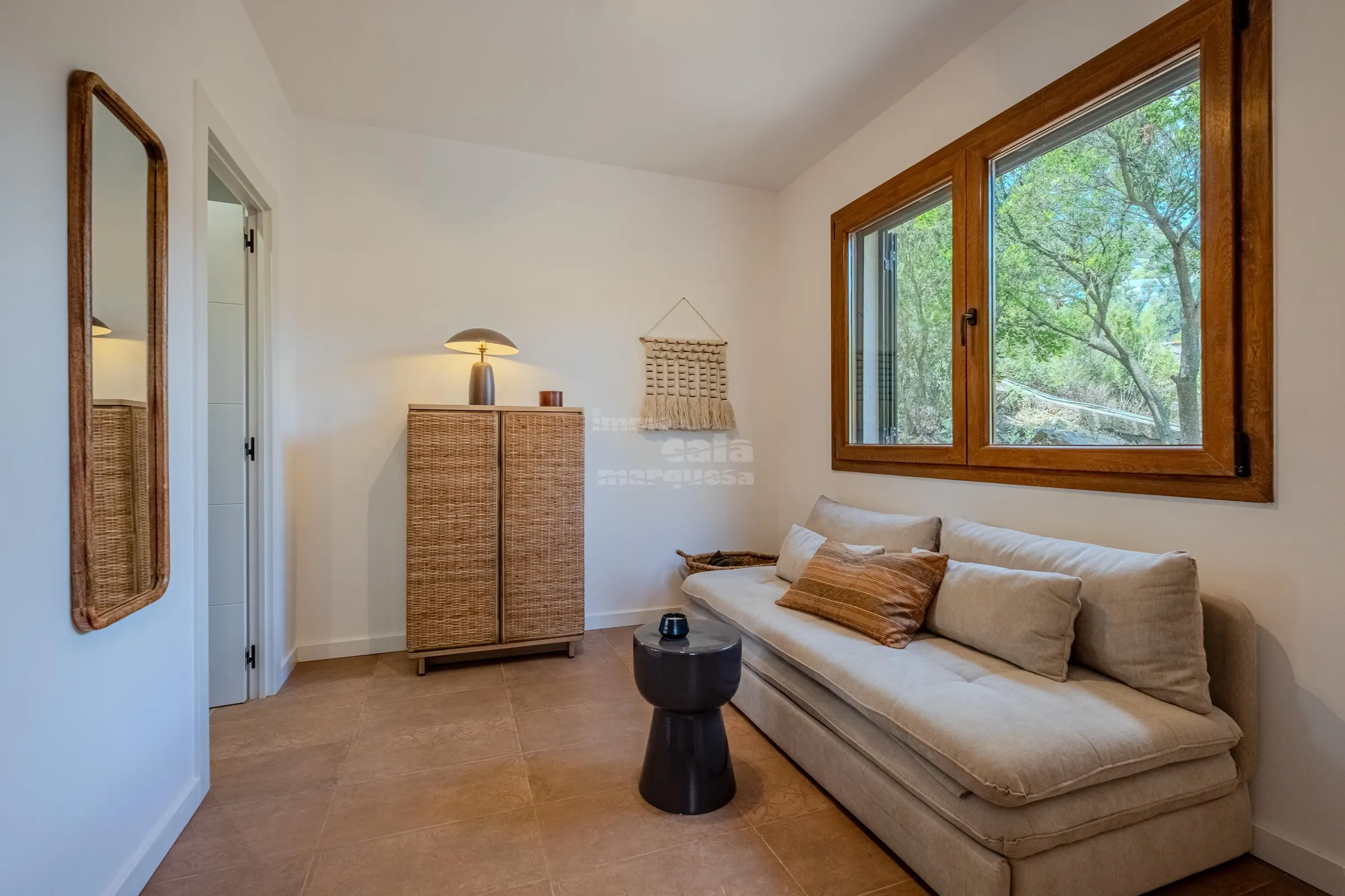 Quiet reading corner with linen daybed, rattan cabinet and garden window