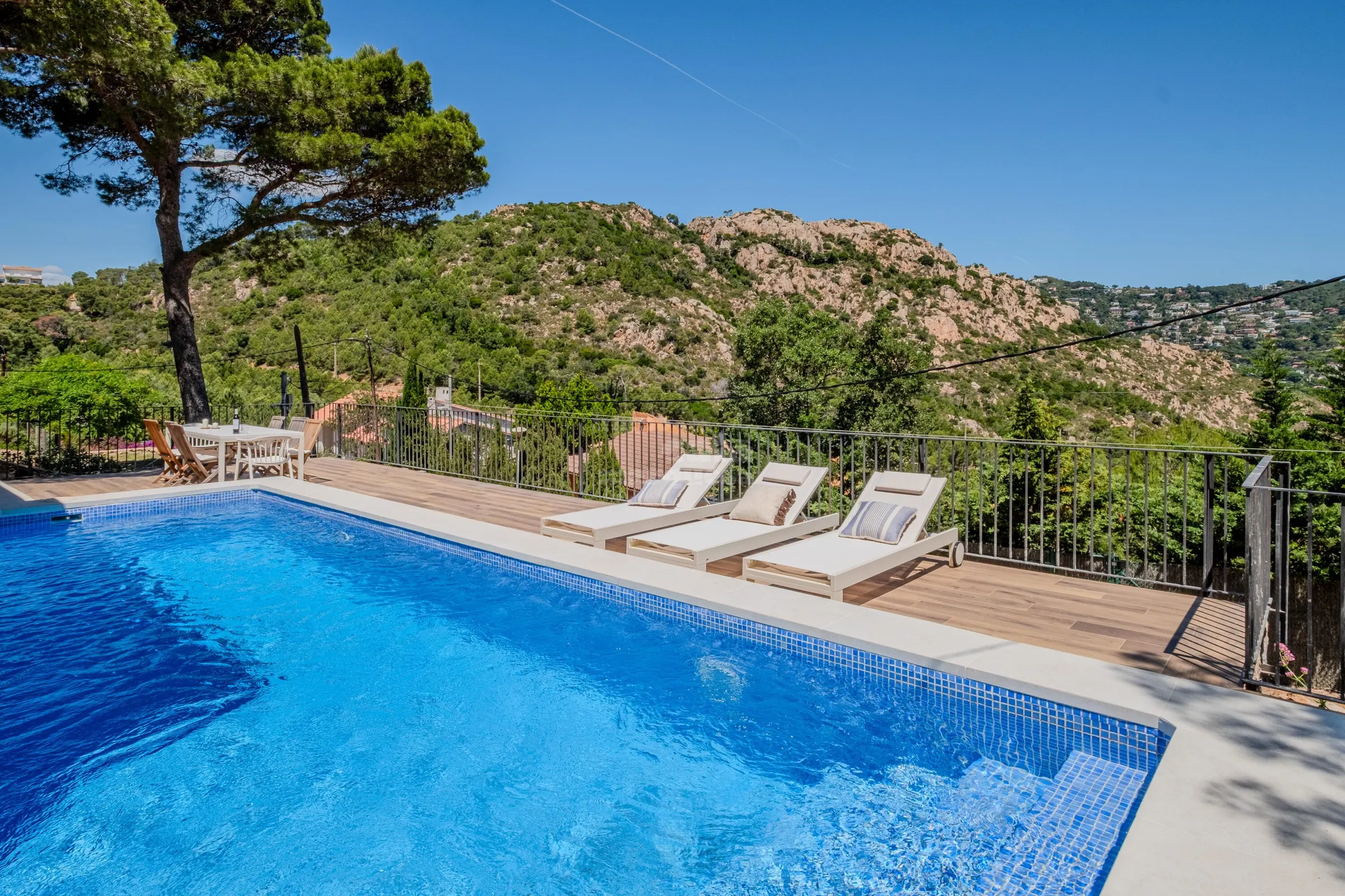 Private pool with three sun loungers framed by pines and the Begur hills