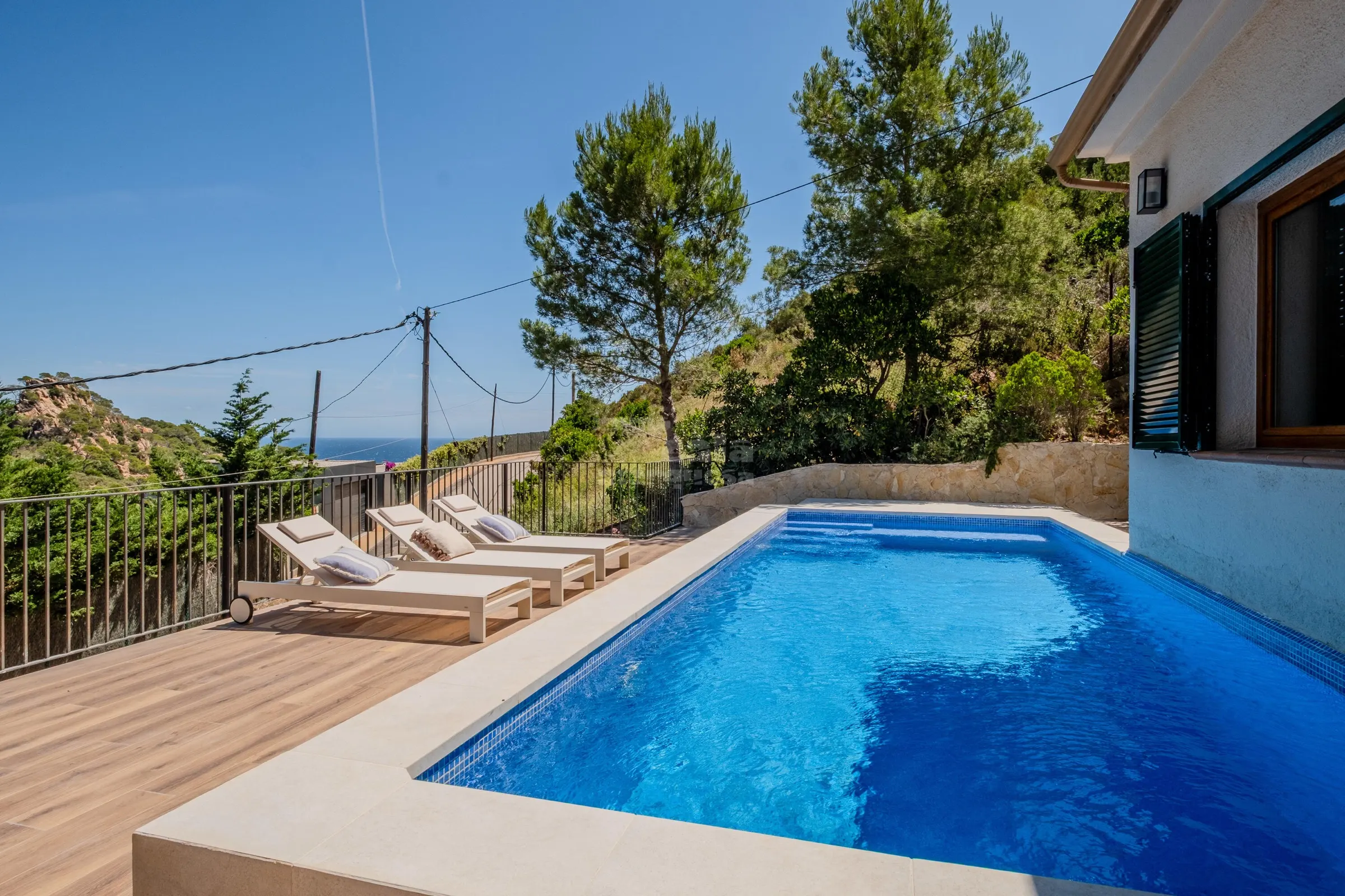 Pool deck with loungers looking out over the Mediterranean